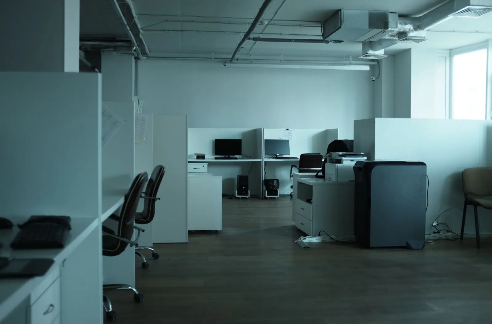 An empty open-plan office with desks and chairs.