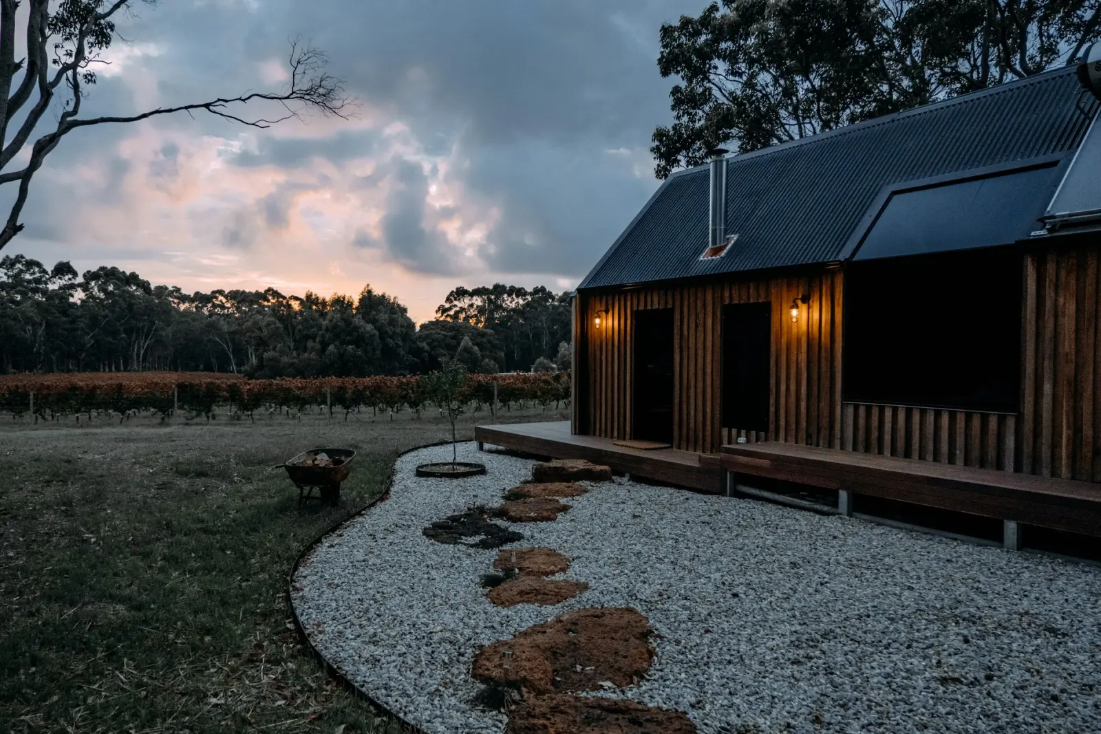 A timber house at twilight in a quiet landscape.