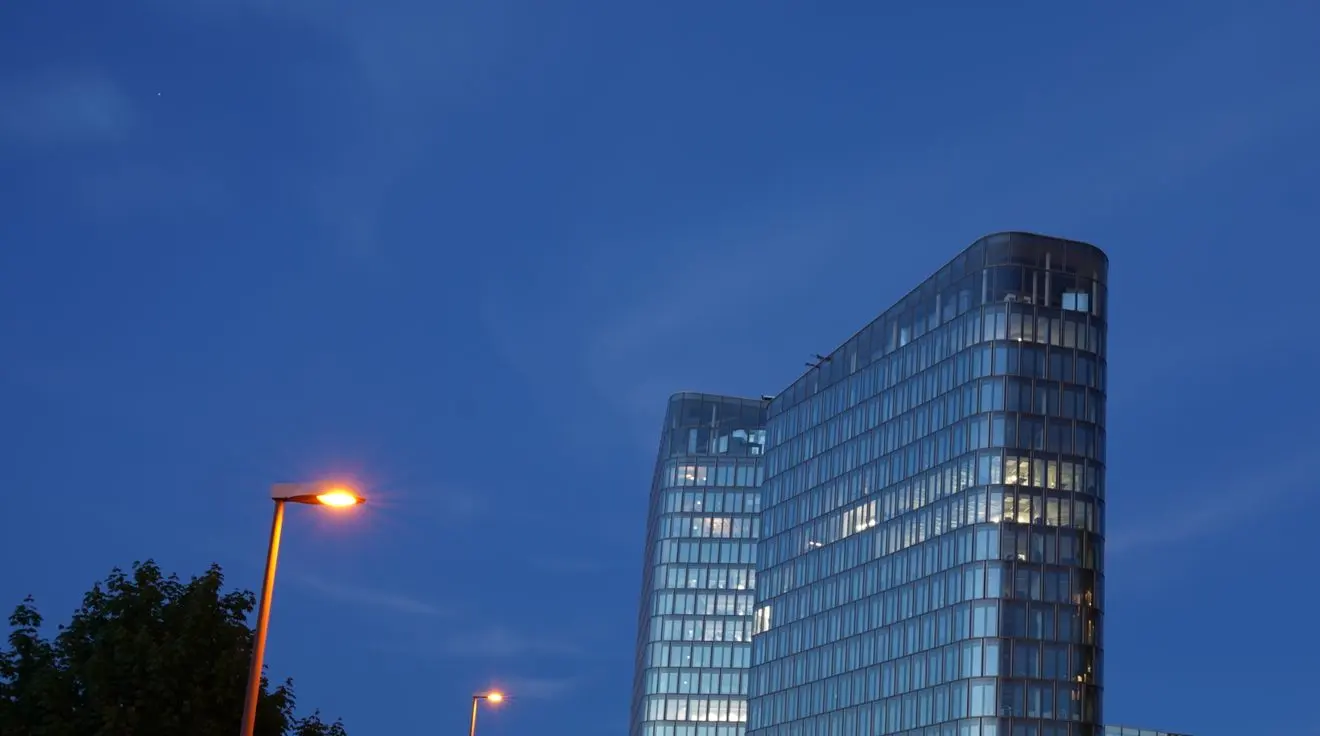 An office tower at dusk under a deep blue sky.